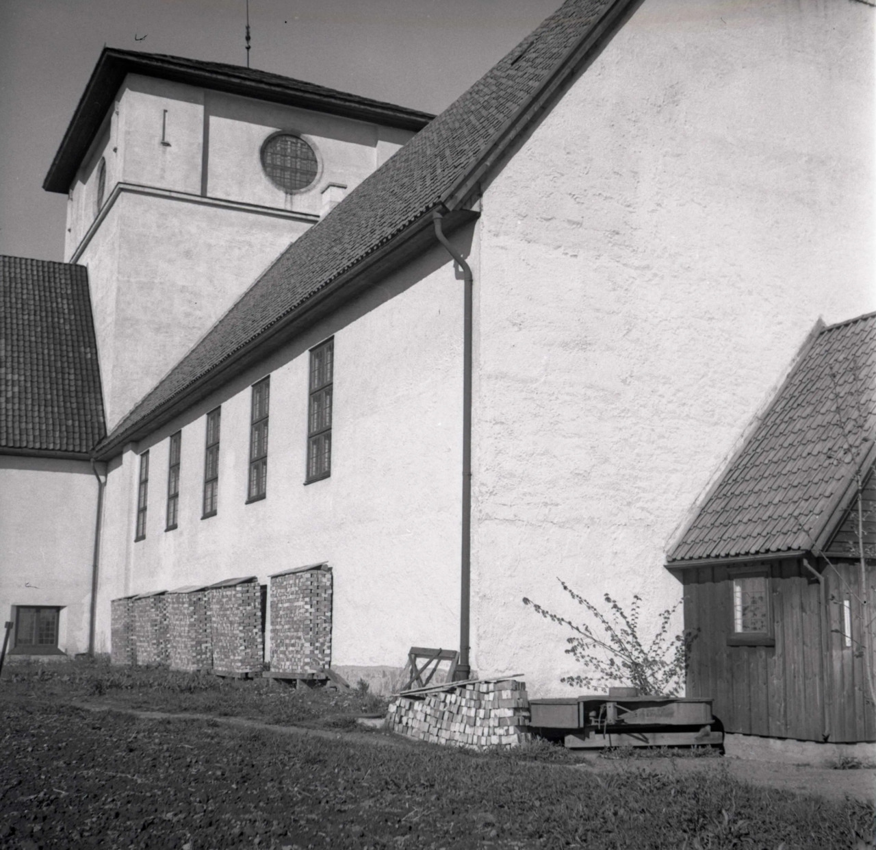 Vikingskipshuset med stabler av murstein foran vinduene til underetasjen.